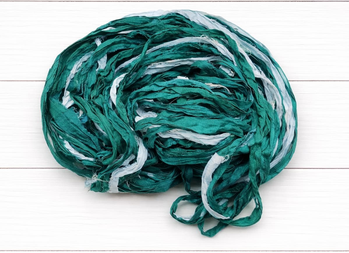 Coiled Ocean Mist sari silk ribbon yarn showing teal and aqua shades