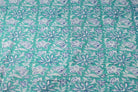 Turquoise cotton fabric with indigo blue and ivory floral vine block print shown as full yardage pattern