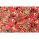 Hand-printed cotton velvet in deep red with blue and orange floral design – flatlay view