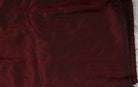 Ruby red Dupion silk fabric laid flat showing colour and natural texture.
